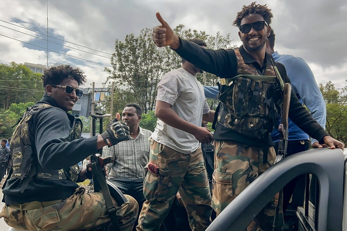 Members of the Ethiopian pro-government Tigray Peace Force (TPF) gesture as residents welcome them while they ride in a pickup truck during a street patrol after Ethiopian federal and allied forces entered the Tigray capital of Mekelle, on October 4, 2026.
