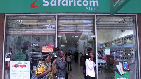 Pedestrians walk past a Safaricom shop in Nairobi on 22 November 2018.
